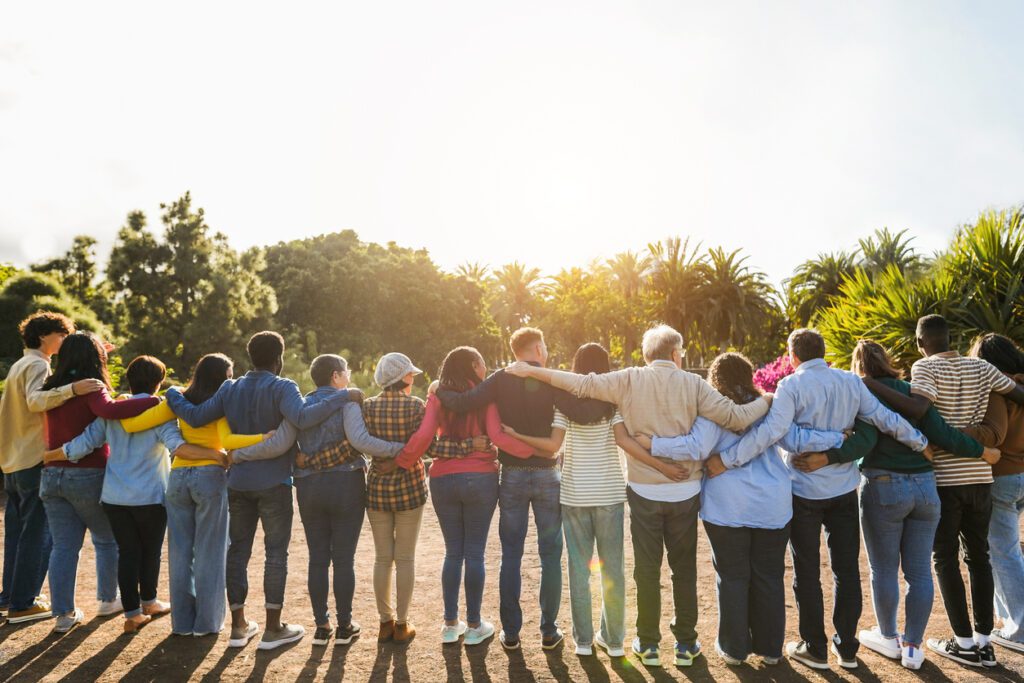 Group of people standing in a line with arms around each other