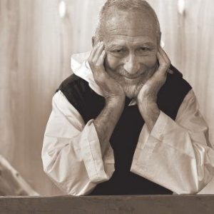 Br. David Steindl-Rast smiling with elbows on the table, hands cupping his cheeks. Cover of his book "i am through you so i"
