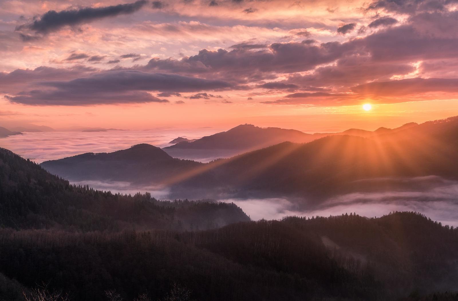 Sun shining over a range of mountains