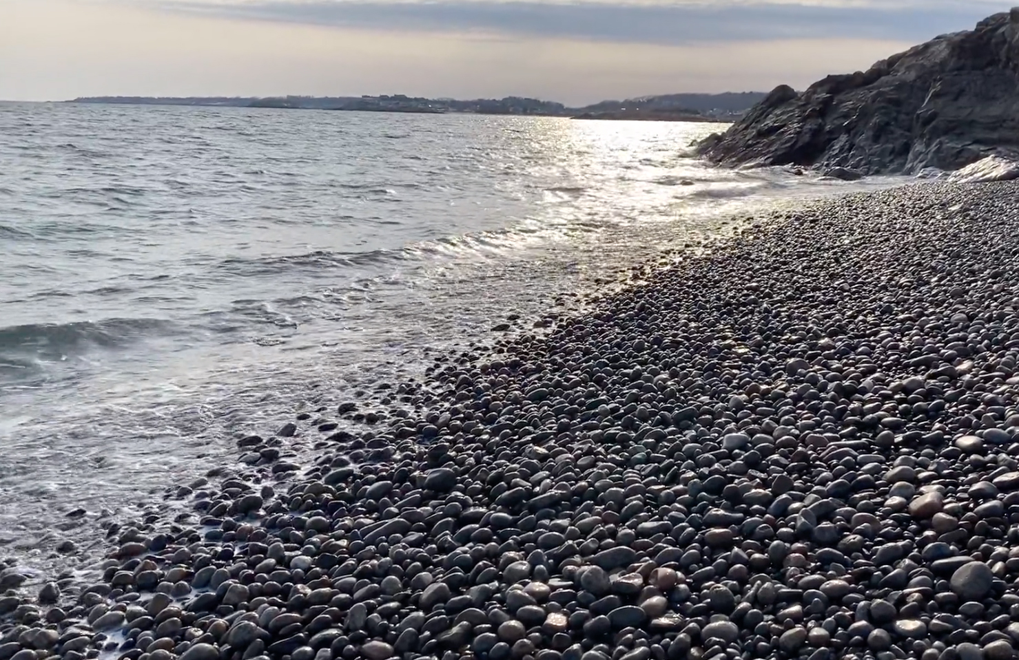 Pebble beach with waves crashing on shore