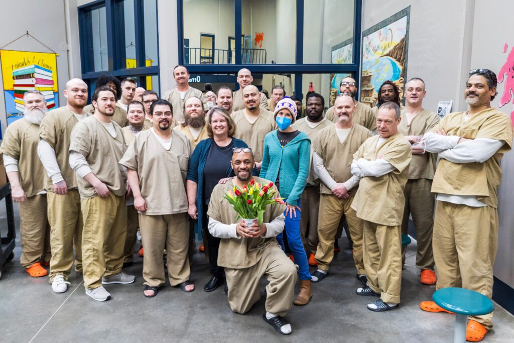 Photo of a group of incarcerated men from Elkhart County Jail in Indiana with artist and instructor Brooke Rothshank, who taught a five-session course on painting miniatures with an emphasis on gratitude