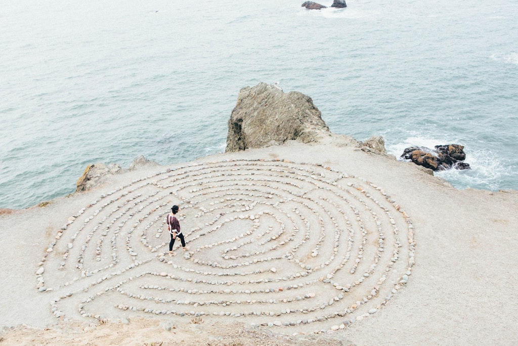 a person walking a labyrinth on the beach