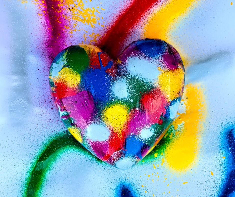 A heart shaped stone spray painted with multiple colors
