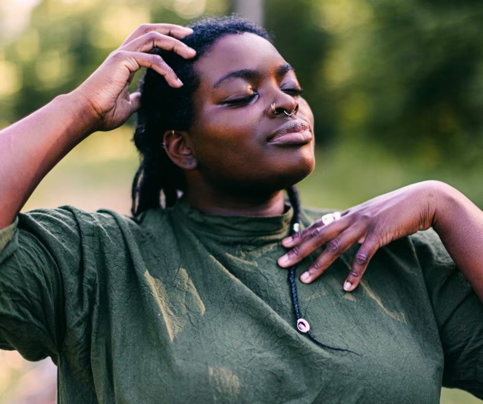 Woman in a green shirt with hand on head